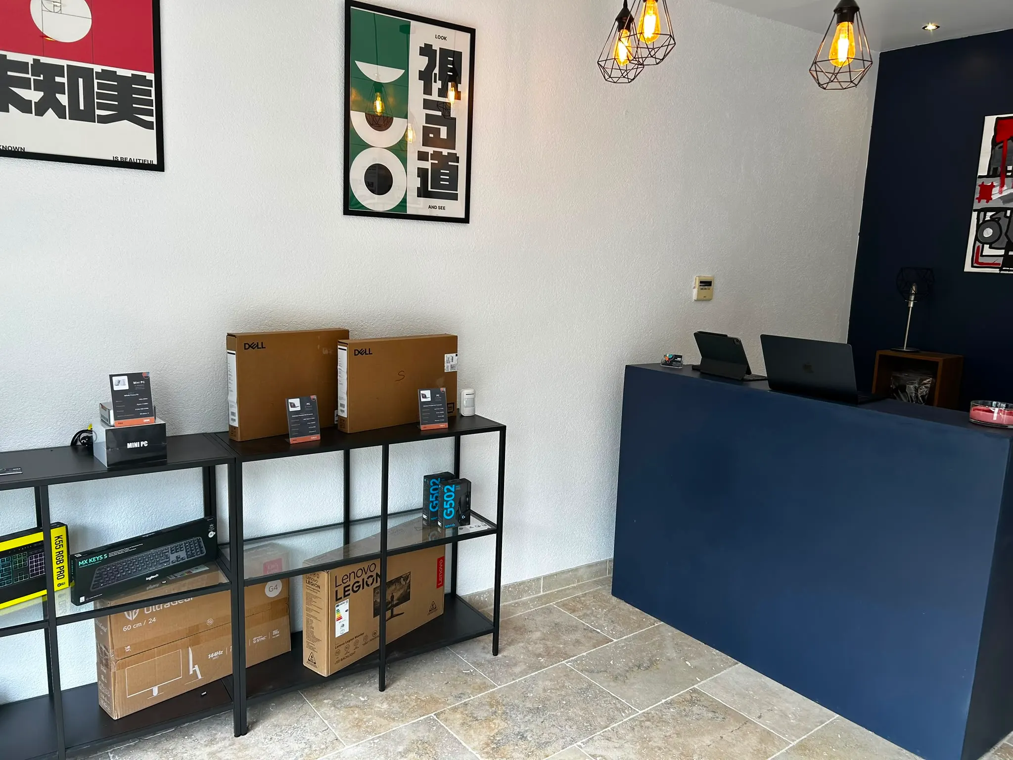 L'intérieur de la boutique Jean K Informatique : comptoir, rayons de PC portables et périphériques